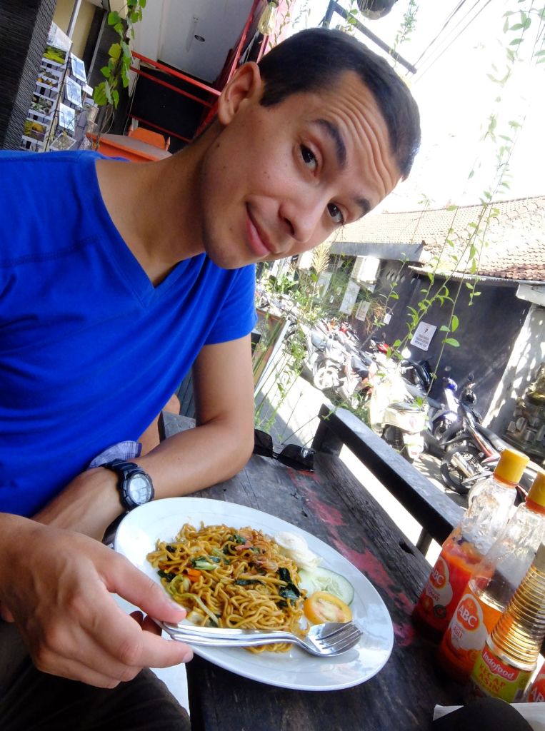 Guy with a plate of mi goreng or Indonesian fried noodles